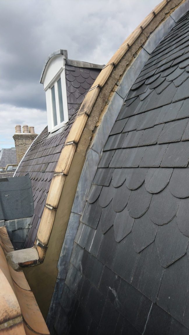 Natural slate mansard roof with lead flashing detail